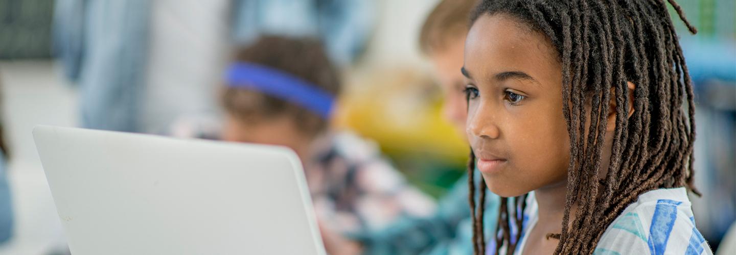 A young child works at a computer