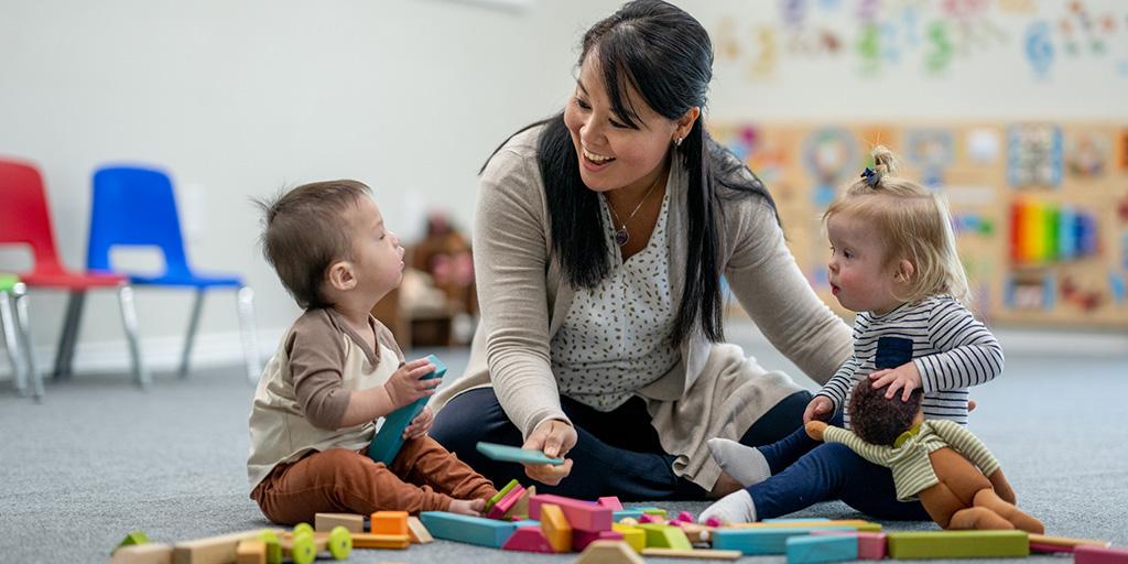 a caregiver teaches two young children