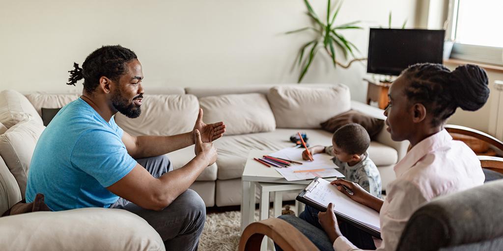 a family service worker talks to a father and child