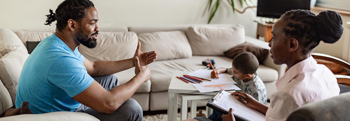 a family service worker talks to a father and child