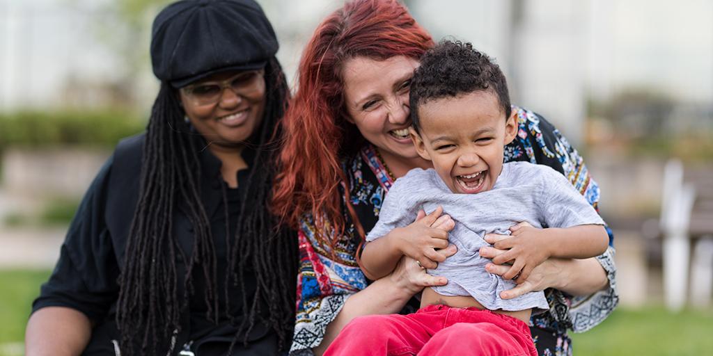 two mothers holding their child