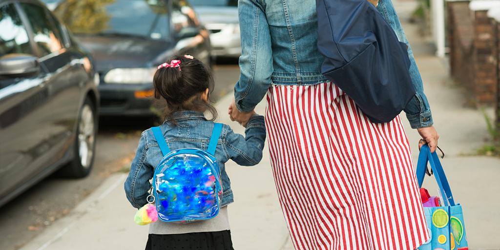 Muslim mother in hijab taking daughter to school