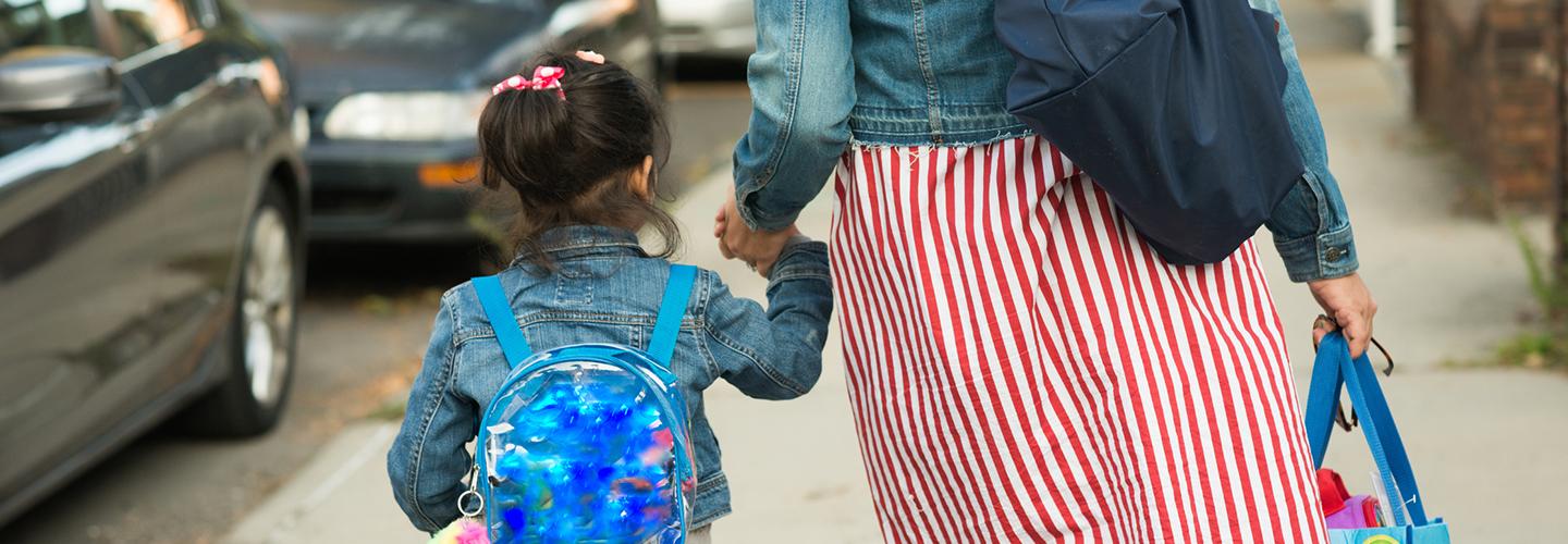 Muslim mother in hijab taking daughter to school