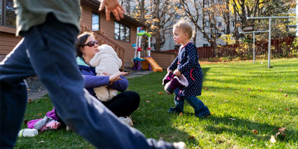 a young girl is outside with her parents