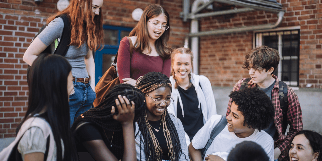 A group of teenagers sitting outside